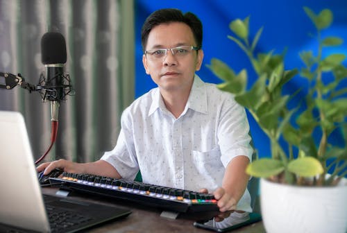 A Man in Eyeglasses in Front of the Laptop