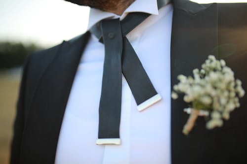 Free Untied Bow Tie of a Man with Flowers on the Coat Stock Photo