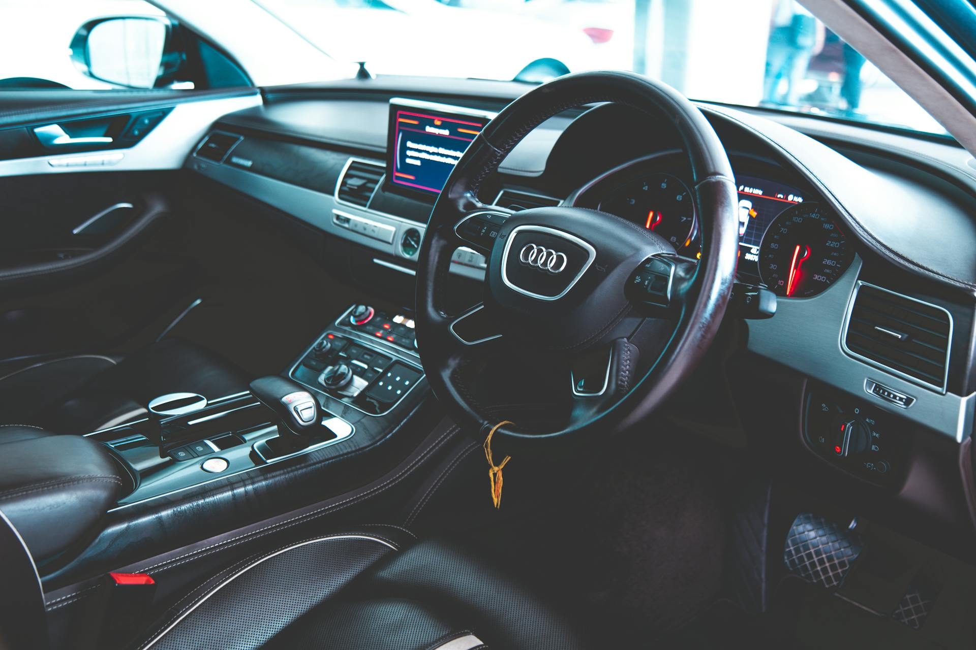 Explore the opulent interior of a luxury Audi car featuring a detailed dashboard and steering wheel.