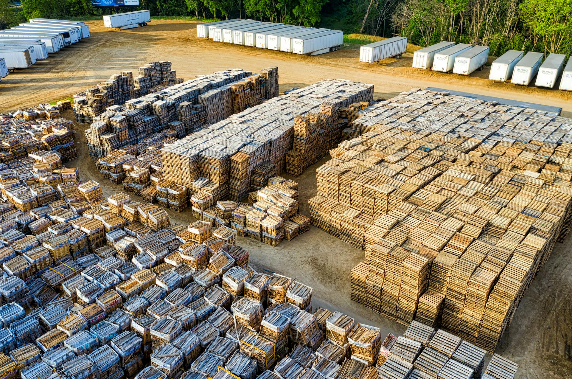 An aerial view of stacked wooden pallets in a warehouse yard, showcasing industrial storage arrangement.