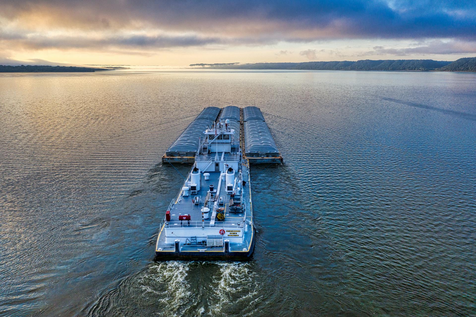 A picturesque aerial shot of a barge navigating Lake Pepin at sunrise, capturing serene water views.