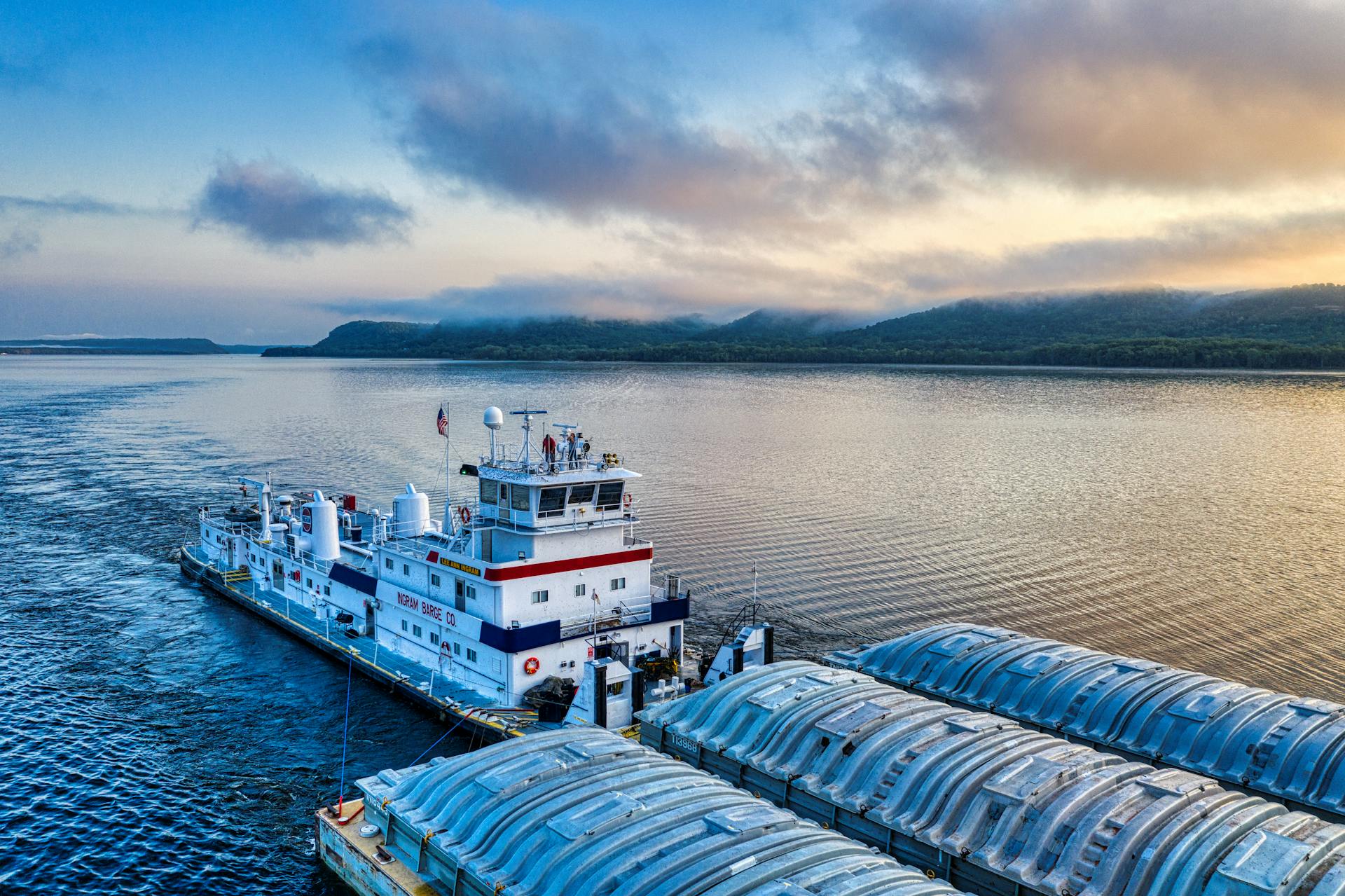 Misty morning at Lake City, MN with a barge on calm waters, under soft sunrise light.