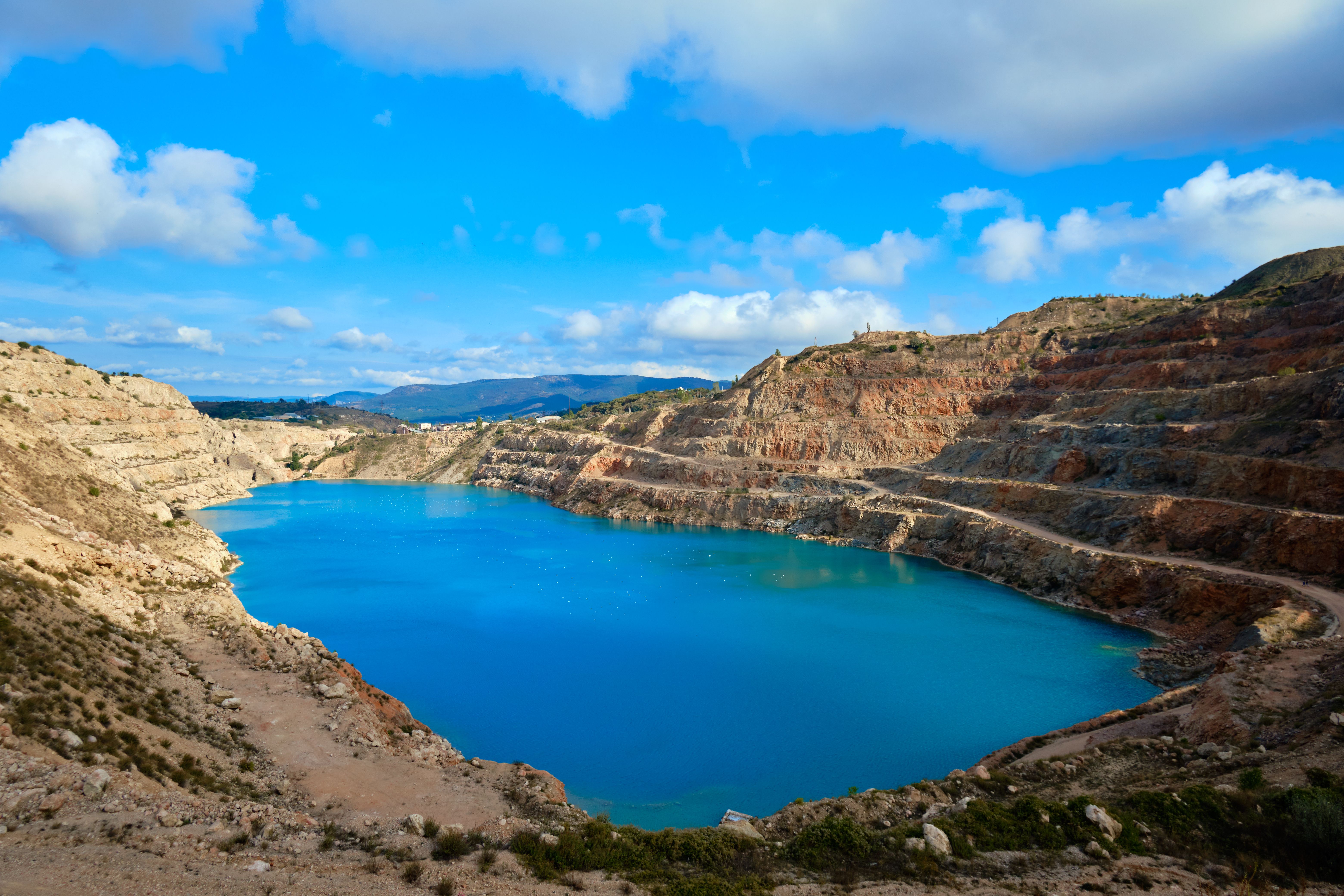 Explore the breathtaking view of a vibrant blue lake nestled in the rugged Sevastopol quarry landscape.