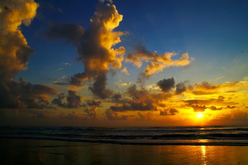 Free A breathtaking sunrise over Navegantes Beach, Brazil, with vibrant clouds and ocean waves. Stock Photo