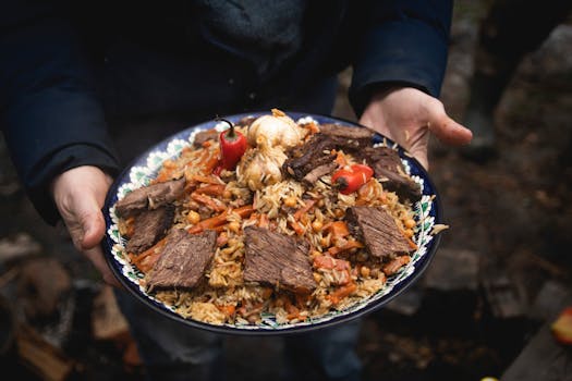 Close-up of homemade plov with meat served outdoors, showcasing vibrant colors and detailed textures.