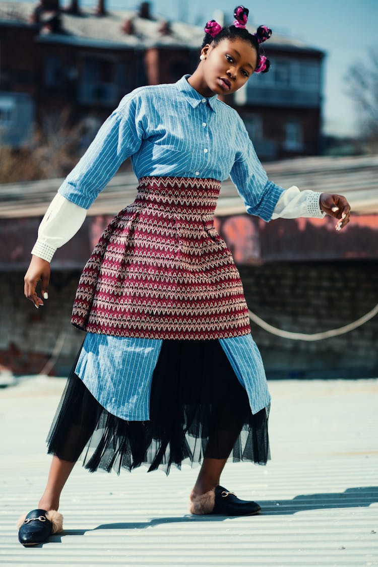 Woman Wearing Blue Long-sleeved Shirt And Red Skirt Standing On Roof