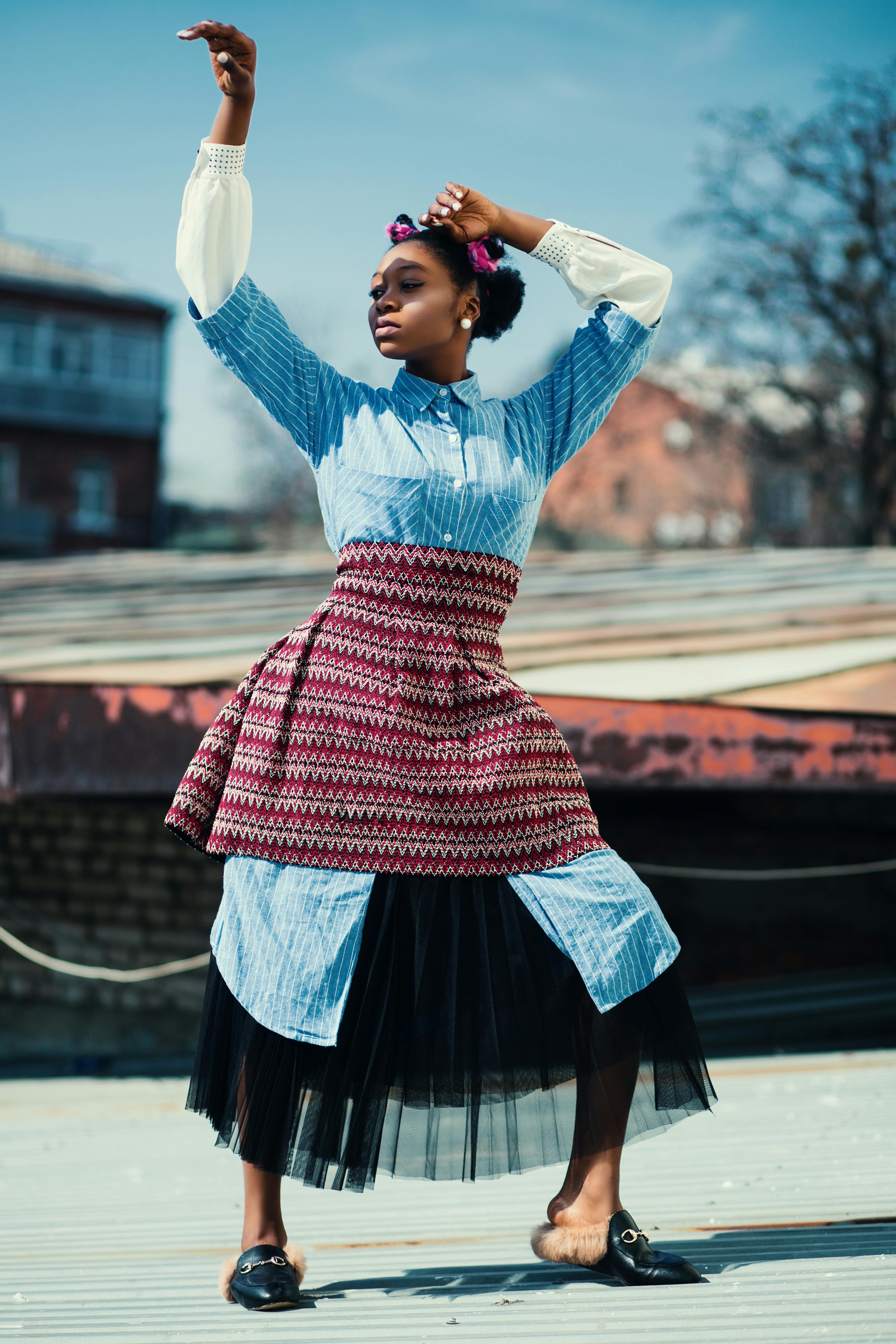Woman Wearing Blue Long-sleeved Shirt and Red Skirt Standing on Roof · Free  Stock Photo