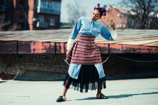 Dynamic shot of a stylish model posing on a rooftop in urban Ukraine.
