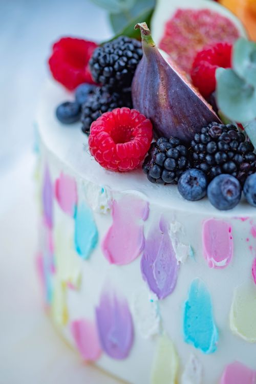Free A close-up of a colorful cake topped with fresh berries and figs, perfect for celebrations. Stock Photo
