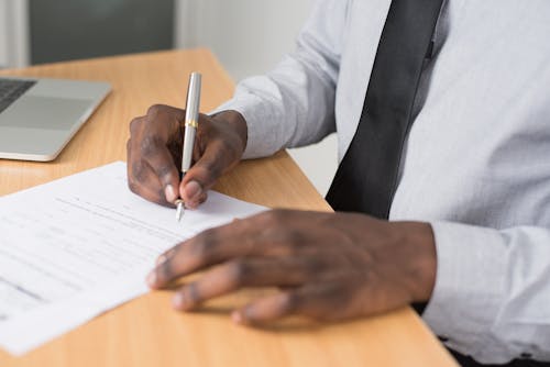Person Wearing White Dress Shirt Signing Contract