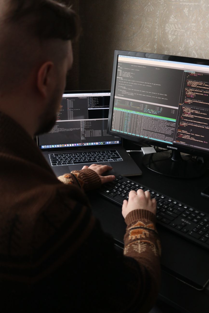Developer reviewing code on a workstation with dual monitors