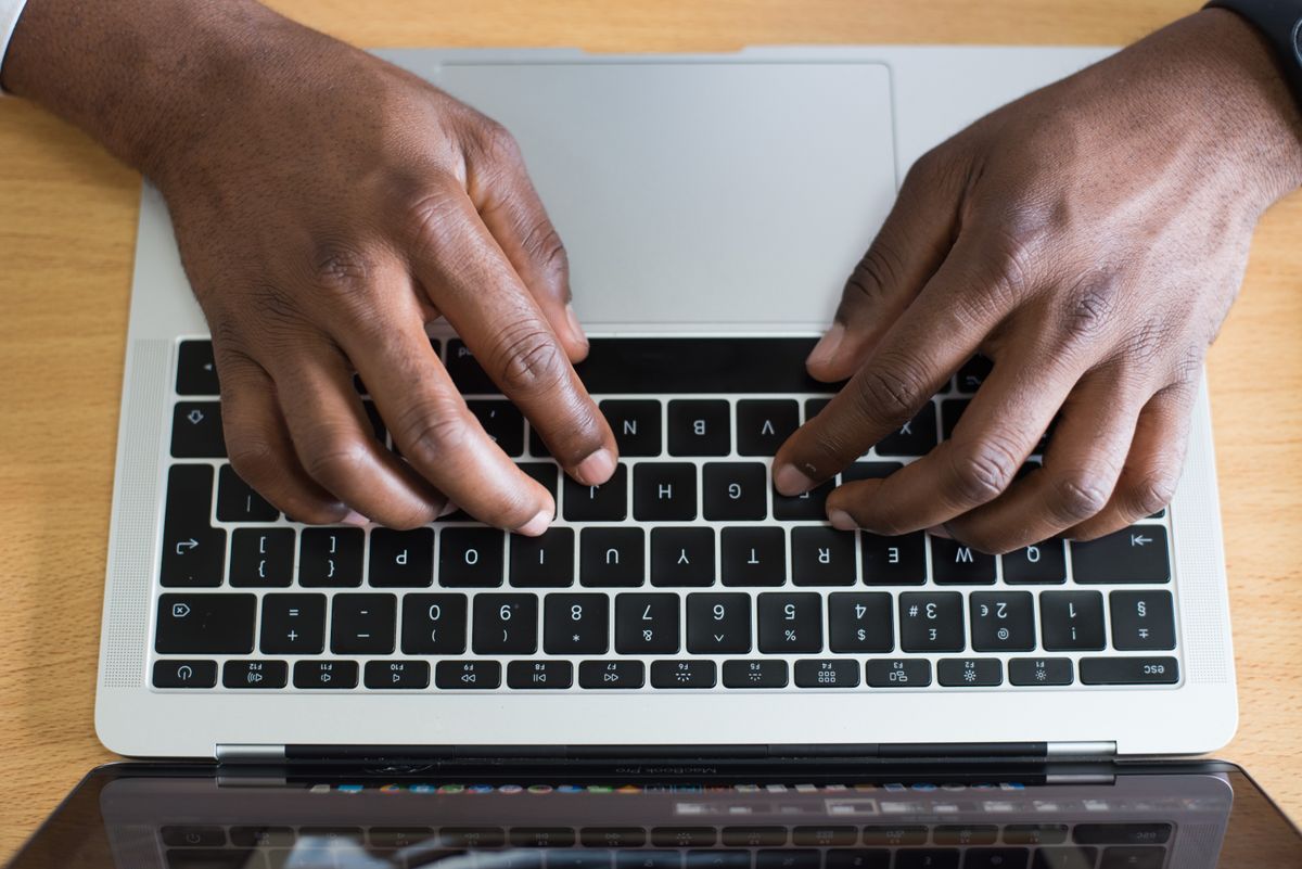 Người dùng thao tác trên bàn phím laptop để cài đặt website