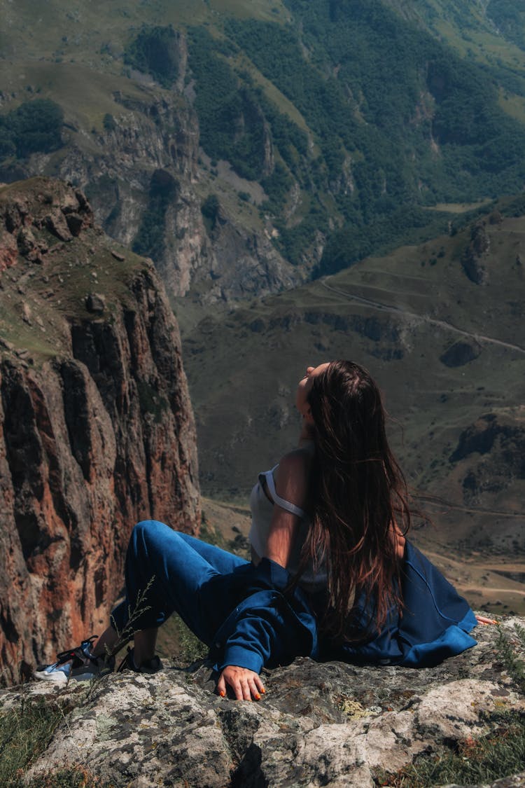 A Woman Posing At The Edge Of A Cliff