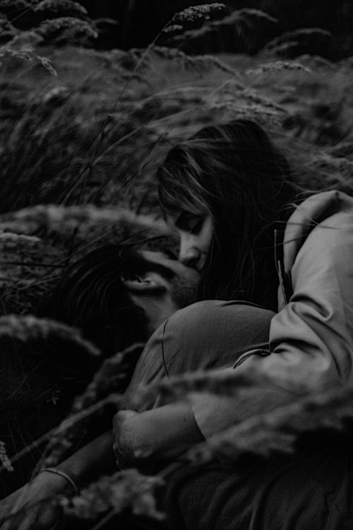 Free A romantic black and white photo of a couple embracing in a field, capturing love and intimacy. Stock Photo