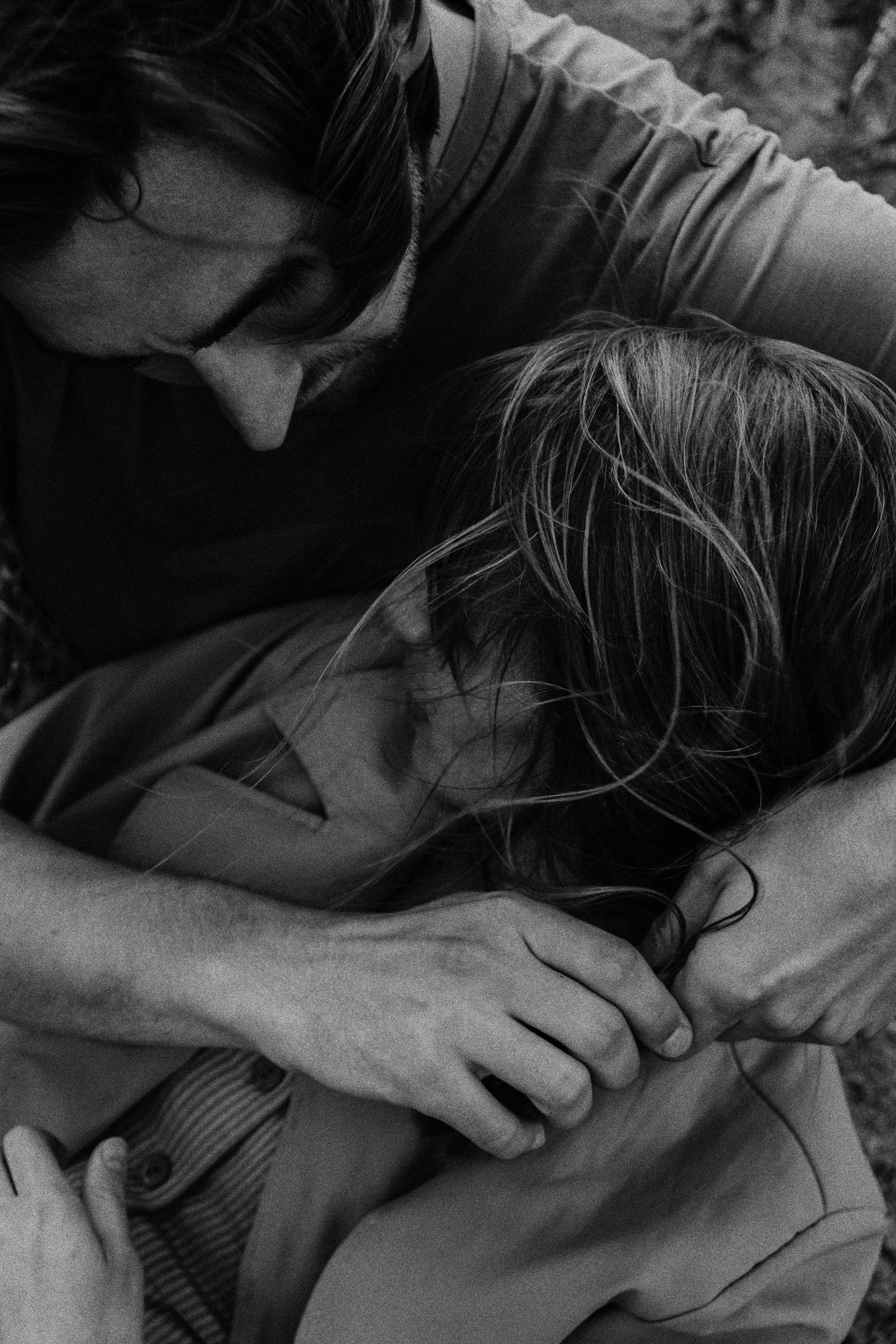 A tender black and white close-up of a couple embracing, expressing love and connection.
