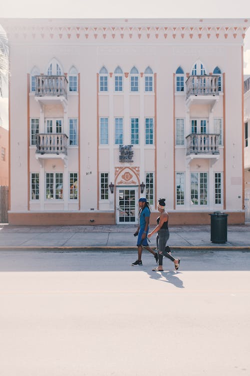 Man and Woman Walking in Front of a Building