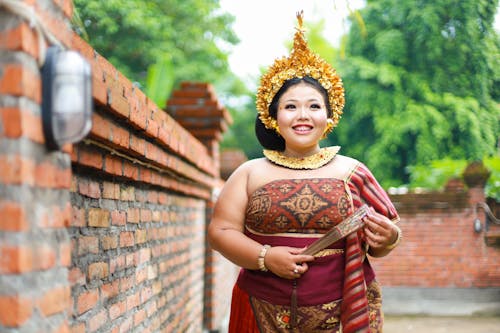A Woman Wearing a Traditional Dress and Holding a Fan