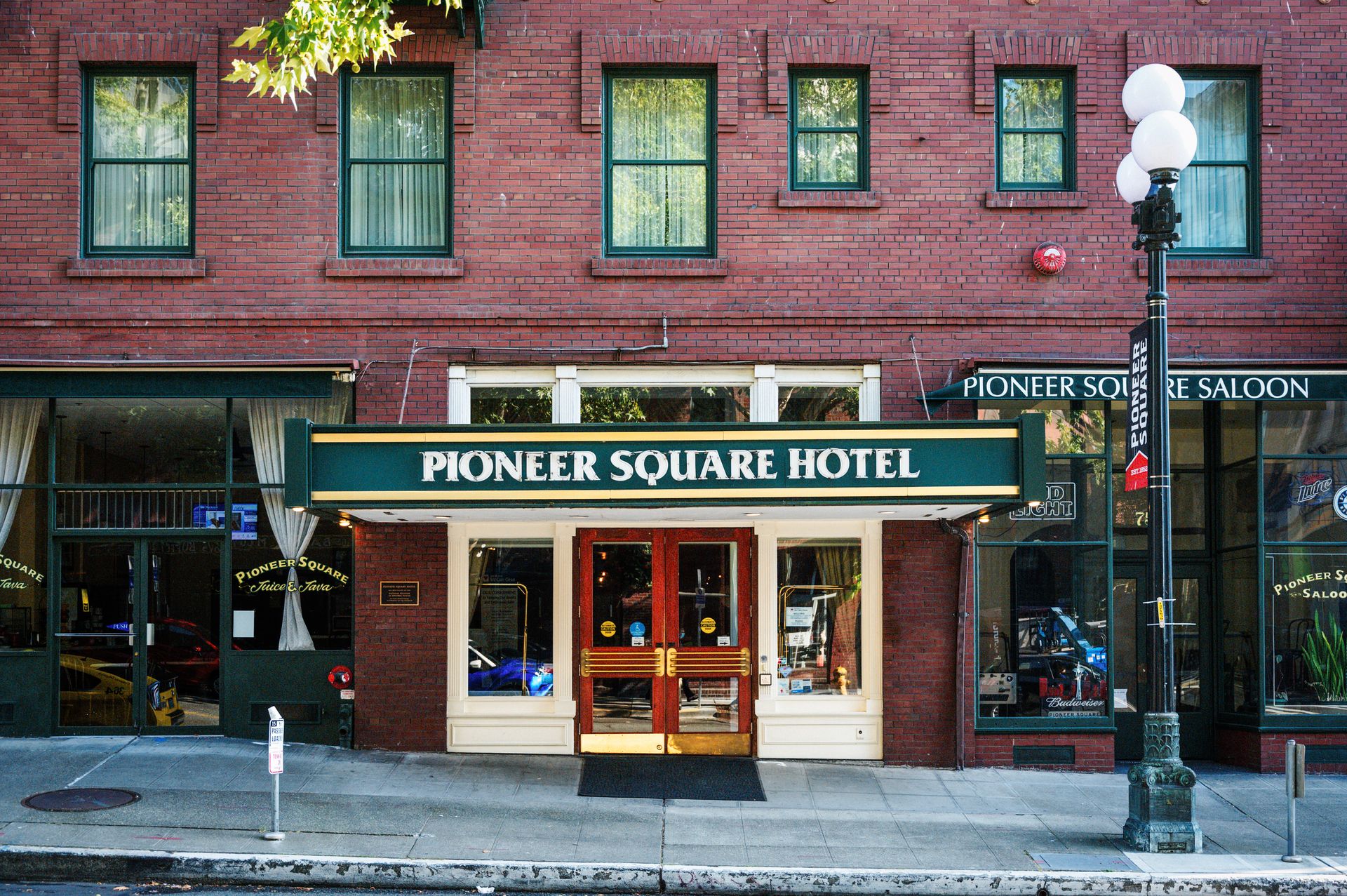 Street view of Pioneer Square Hotel entrance with historic brick facade.
