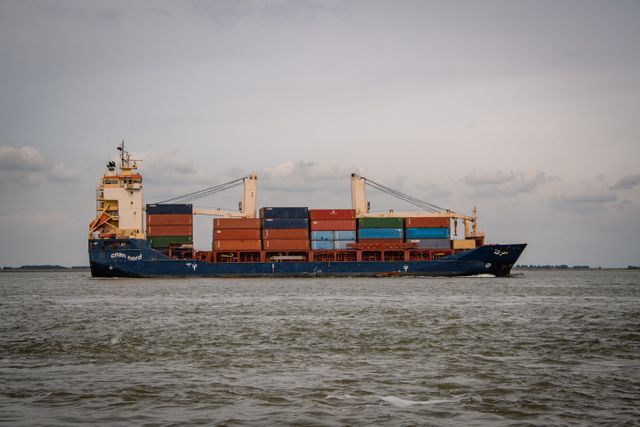 Container ship sailing through calm coastal waters