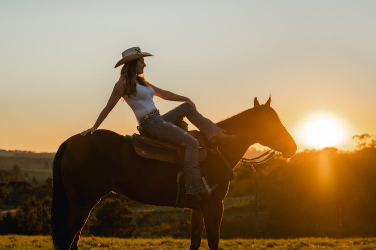 Woman Riding A Horse During Sunset