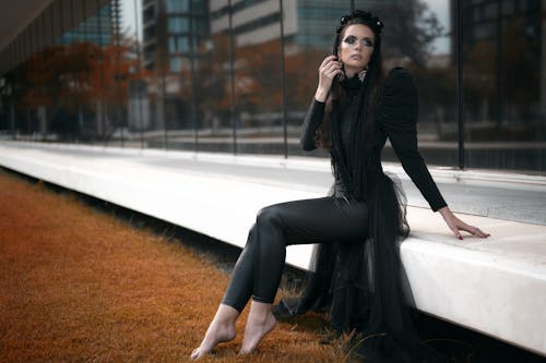 Free Woman in Black Clothes Sitting near the Glass Windows Stock Photo