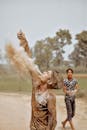 Woman in Black and White Shirt Blowing White Powder