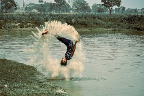A Man Doing a Somersault in to a Pond