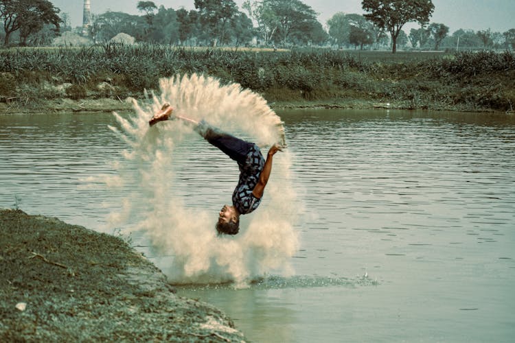 A Man Doing A Somersault In To A Pond