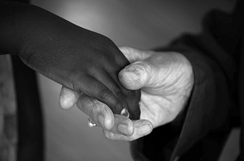 Close-up Photo of Two People holding each other's Hands 