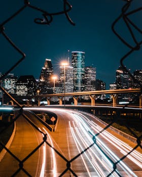 Stunning nighttime view of Houston's skyline featuring light trails from highway traffic.