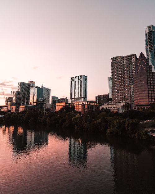 Free Stunning view of the Austin skyline with buildings reflecting in the river at sunset. Stock Photo
