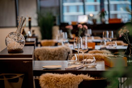 Chic restaurant interior featuring elegant glassware, tableware, and cozy decor.