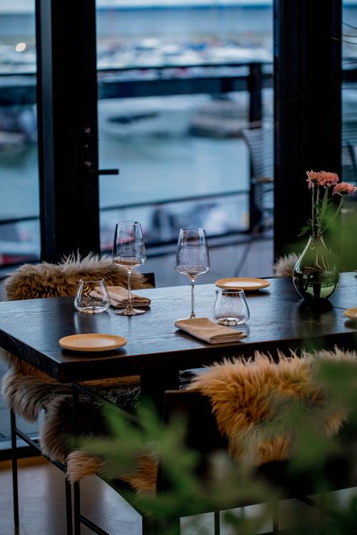 Free Sophisticated table setting with flowers and wine glasses by the waterfront, perfect for elegant dining. Stock Photo