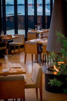 Luxurious restaurant interior with elegant dining setup and waterfront view.
