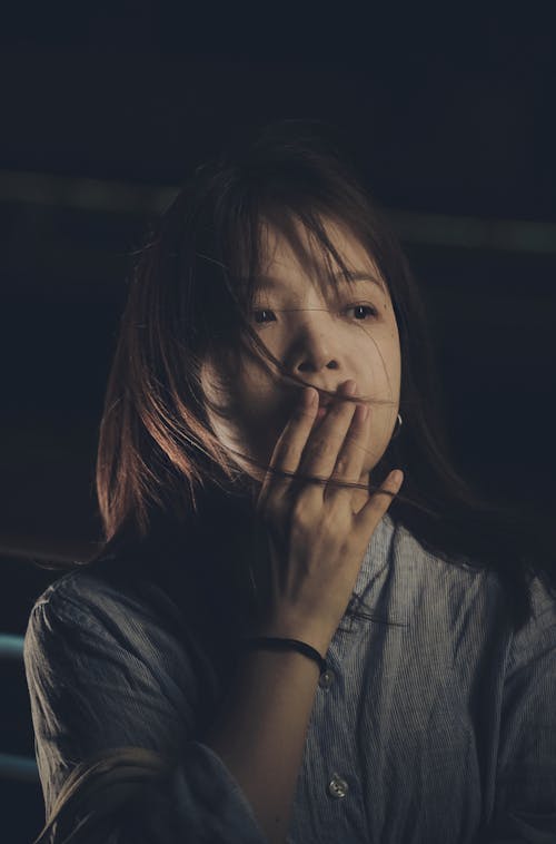 Free A Woman with Her Hand Covering Her Mouth Stock Photo