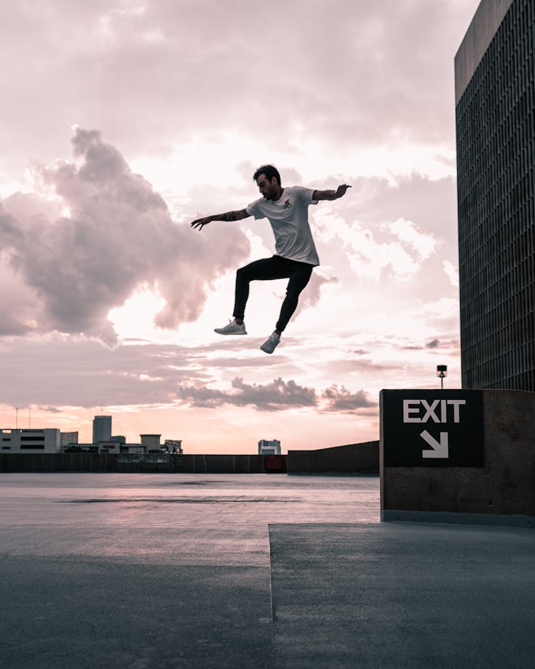 A Man Jumping High On Mid Air Near Building Exit