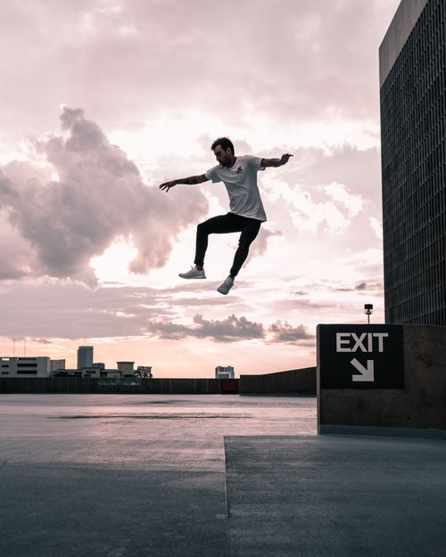 Free Man jumping on rooftop with dramatic Houston cityscape in background. Stock Photo