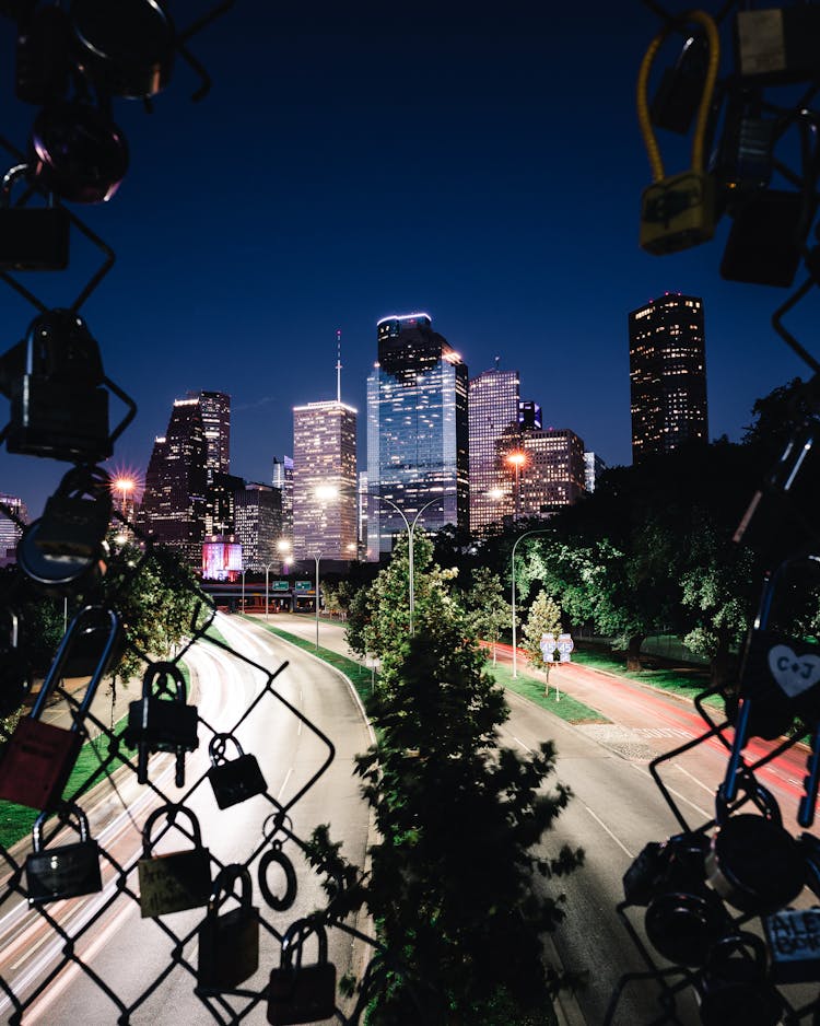 Illuminated City Buildings With A View From The Love Lock Fence In Houston Texas, USA