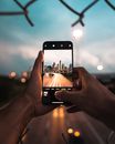 Person Holding Cellphone Taking Photo of Road Near Buildings