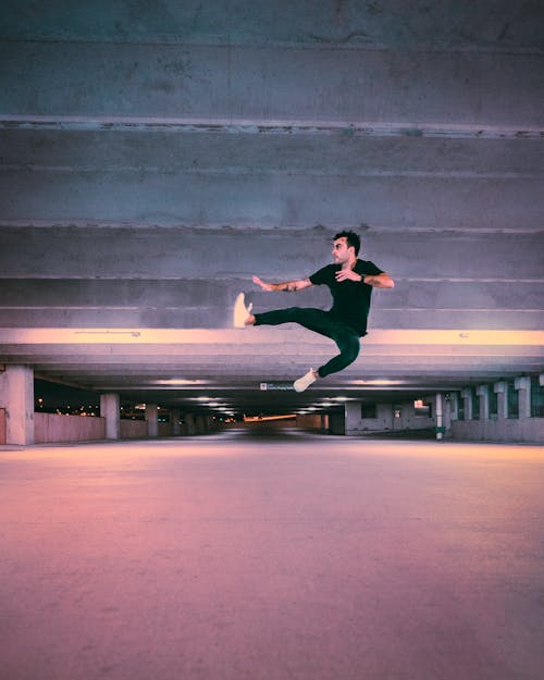 Free Man in Black Jacket and Black Pants Doing Skateboard Stunts on Gray Concrete Floor Stock Photo