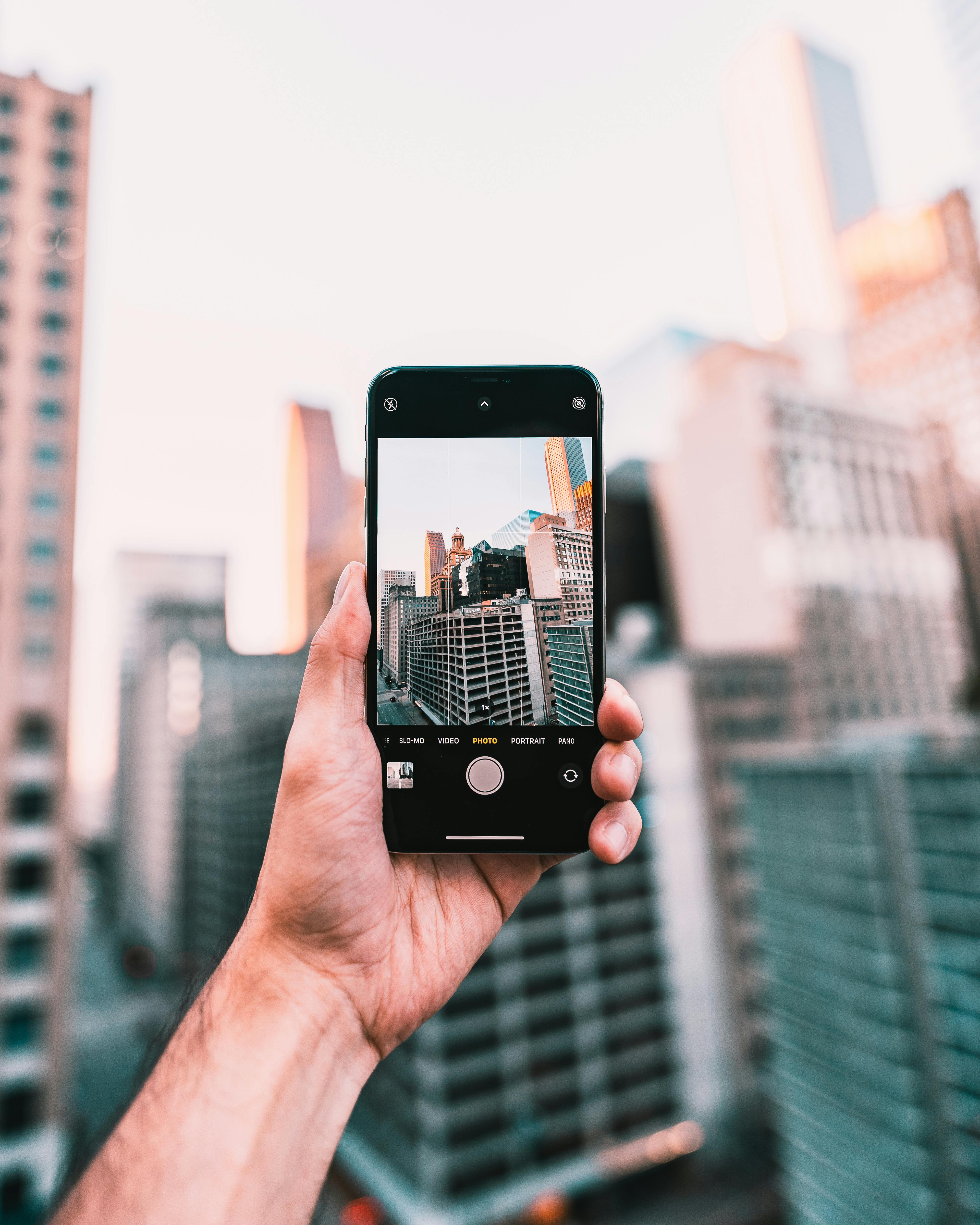Free Hand holding smartphone capturing downtown cityscape in Houston. Stock Photo