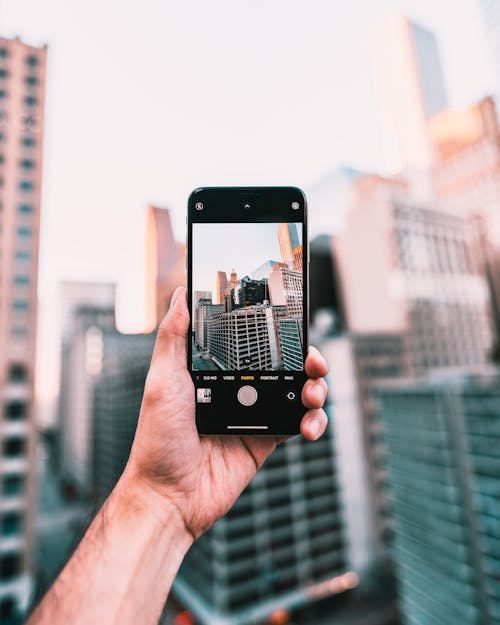 Free Person Holding Black Smartphone Taking Photo of High-rise Buildings Stock Photo