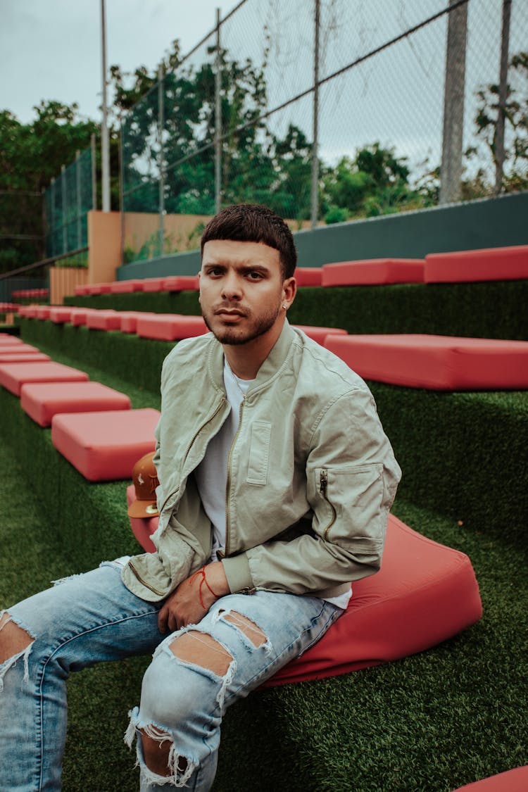 Man In A Khaki Jacket And Ripped Jeans 