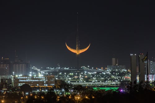 Free Yellow and Black Moon on Top of City during Night Time Stock Photo