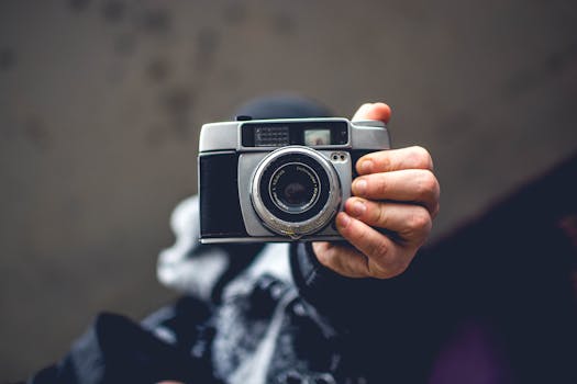 A person holds a classic camera, capturing the nostalgia of photography.