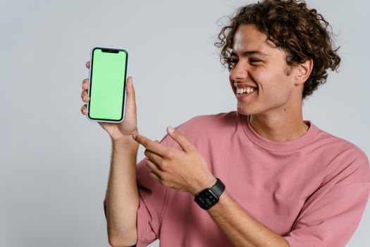 Man in Pink Crew Neck T-shirt Holding Blue Iphone Case