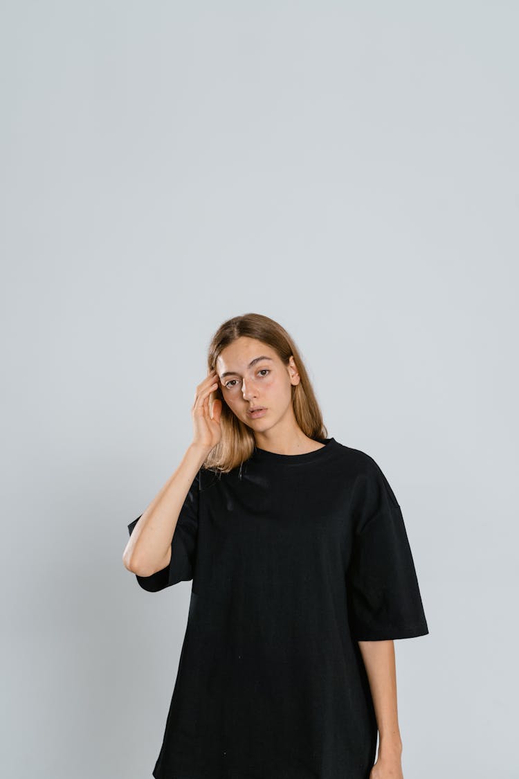 Woman Wearing Black Crew Neck Shirt Standing Near White Wall