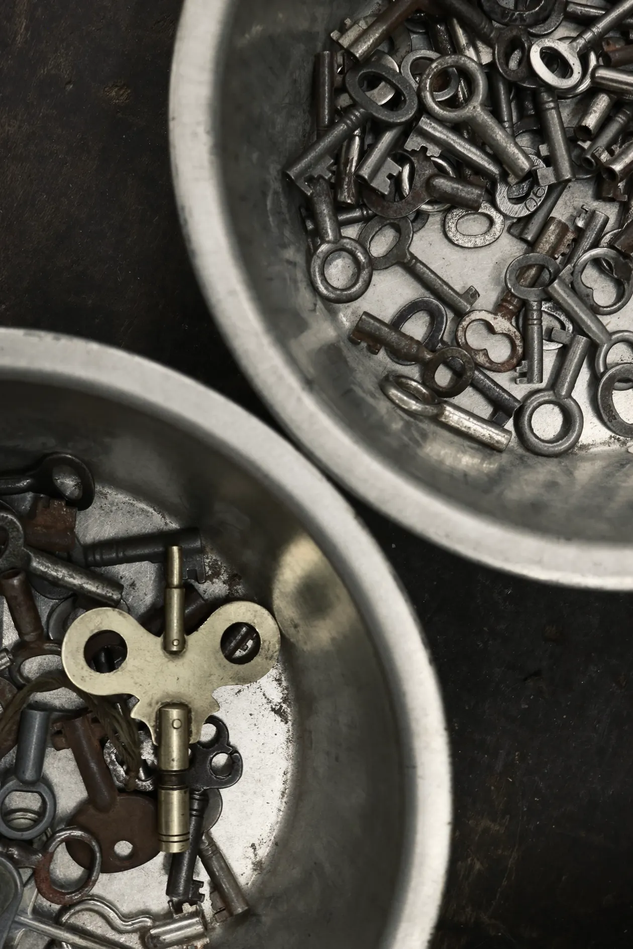 Vintage keys collected in metal bowls for an entryway drop zone