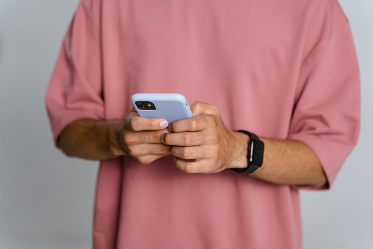 Elinde akıllı telefon tutan kişi canlı maçı takip ederken bahis seçeneklerine bakıyor