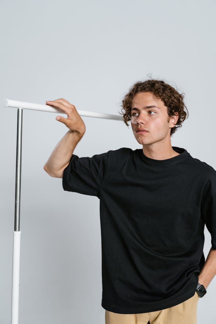 Man In Black Crew Neck T-shirt Holding White Metal Bar